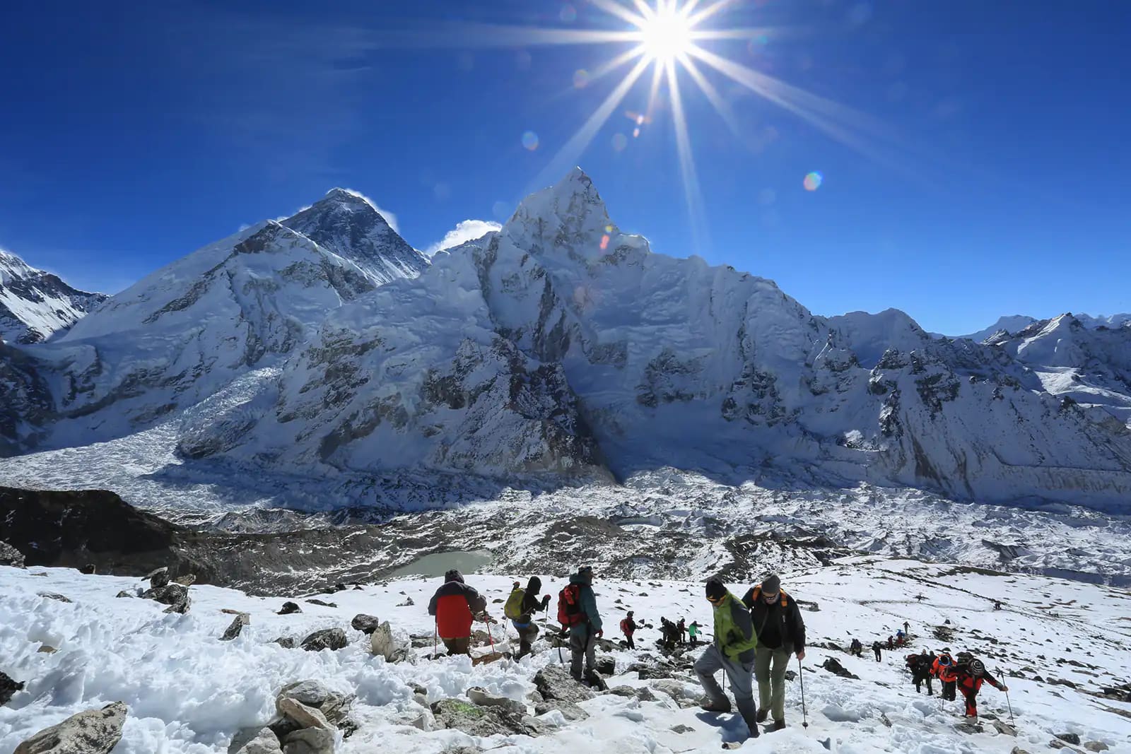 trekker and flare over Nuptse summit beside of Everest from Kala Patthar summit
